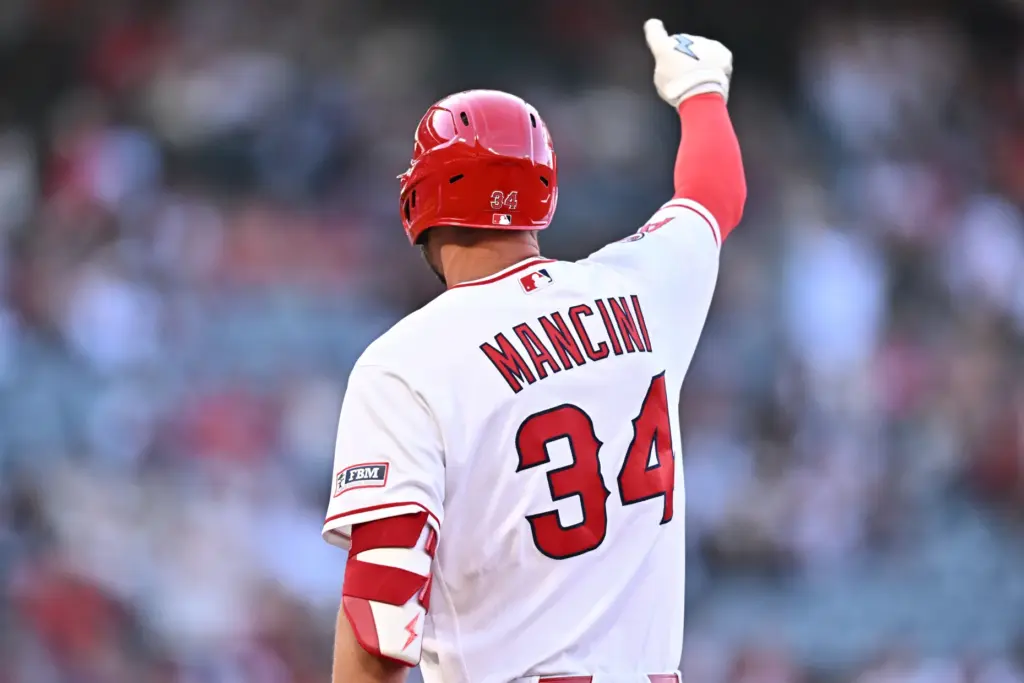 The Angels’ Trey Mancini gestures to teammates in the dugout...