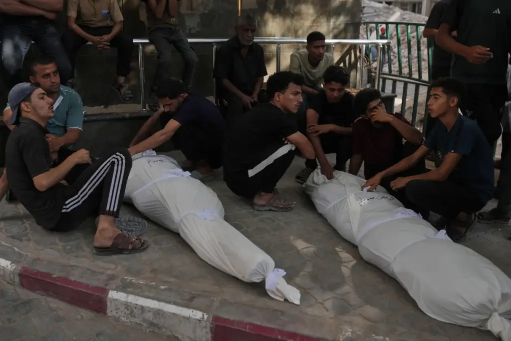 Mourners gather around the bodies of Palestinians killed in an...