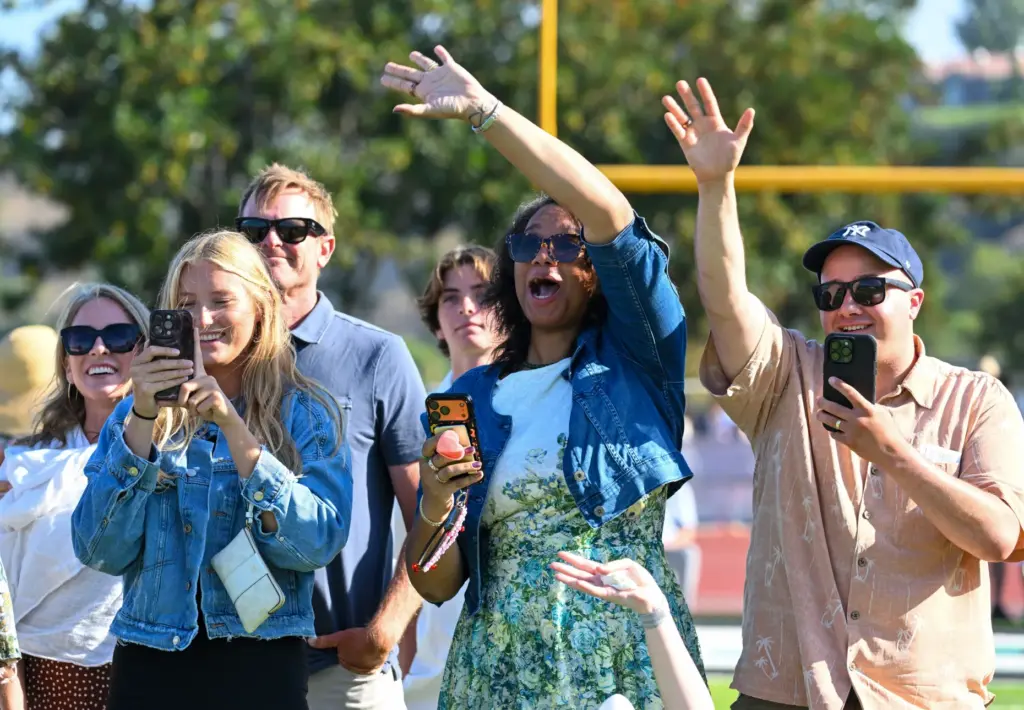 Friends and family wave to graduates during the Aliso Niguel...