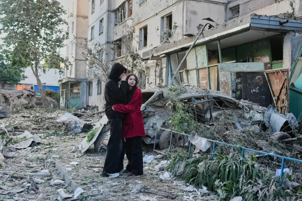 People react as they look at the site of a Russian missile strike.