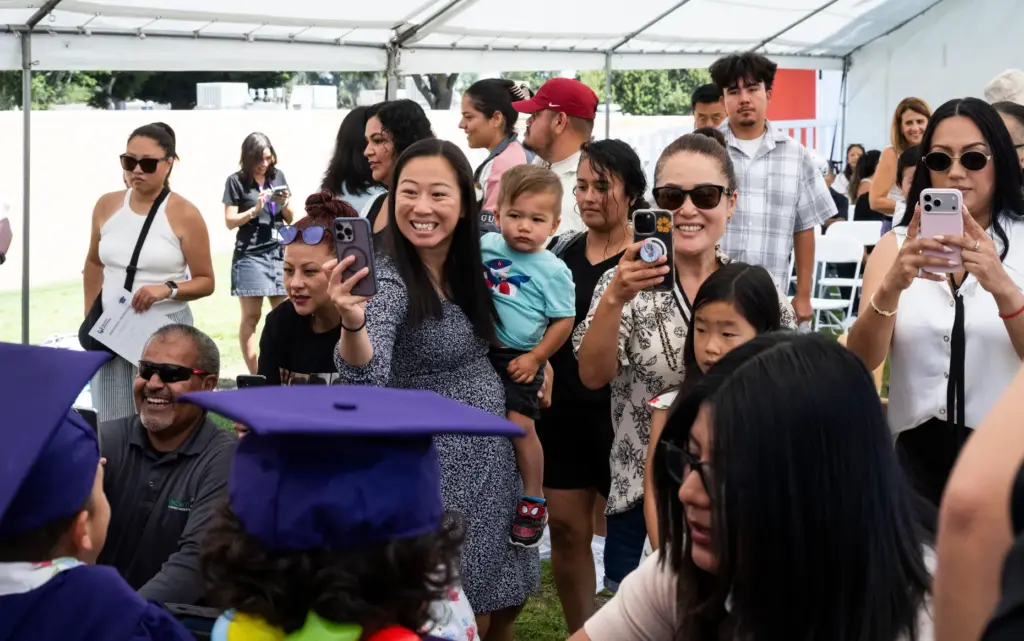 Parents take photos following a preschool promotion ceremony at Beyond...