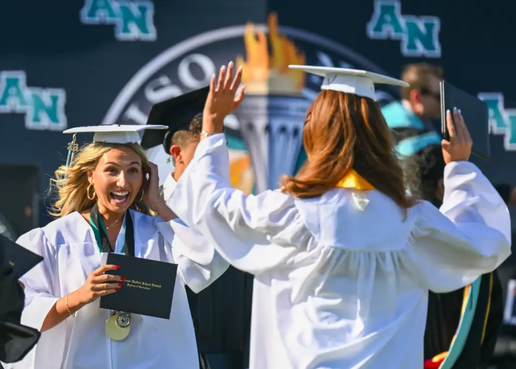 Graduate Liona Pestritto greets a classmate after getting their diplomas...