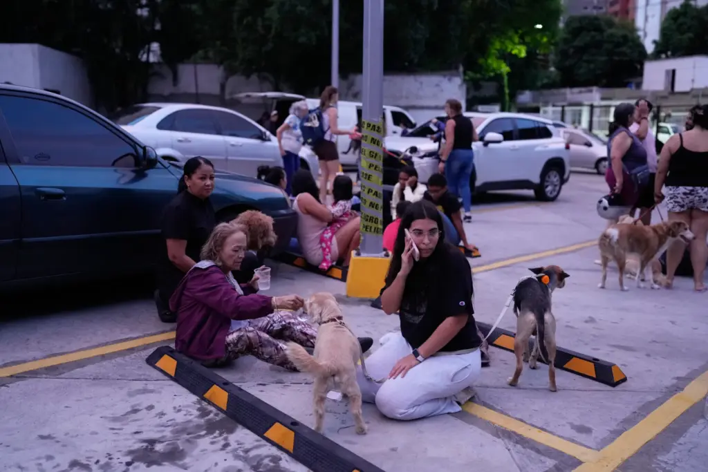 People stay outside their homes after an earthquake in Caracas,...