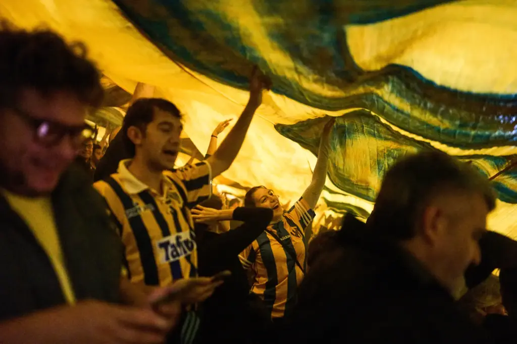 Atlanta fans chant slogans under a flag during a match against Chacarita Juniors.