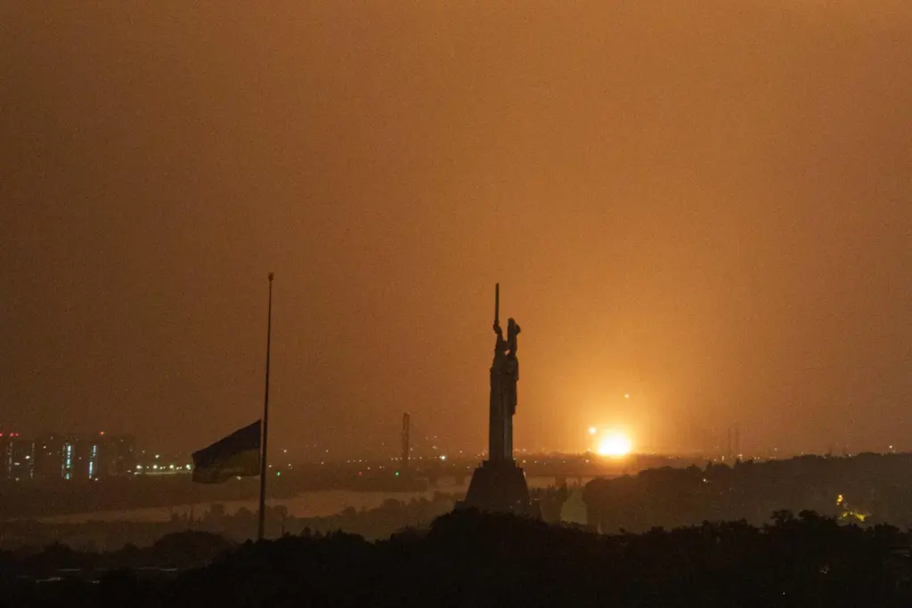 An explosion of a Russian drone on the horizon in front of the Mother Motherland monument.
