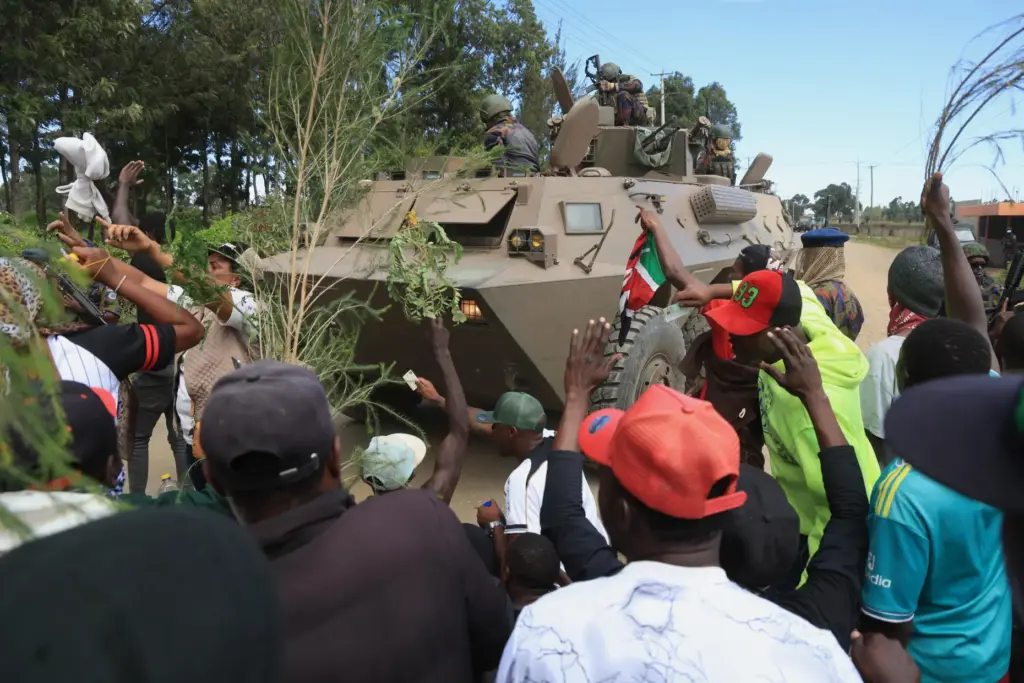 Kenyan soldiers on a tank patrol as protesters demonstrate.