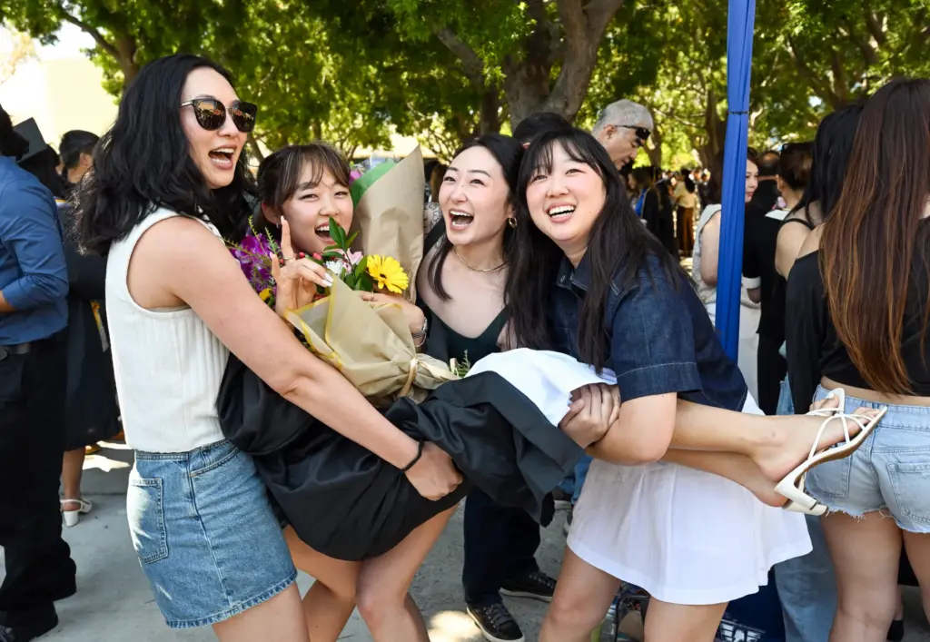 Graduate Abigail Yoo is lifted off the ground by friends...