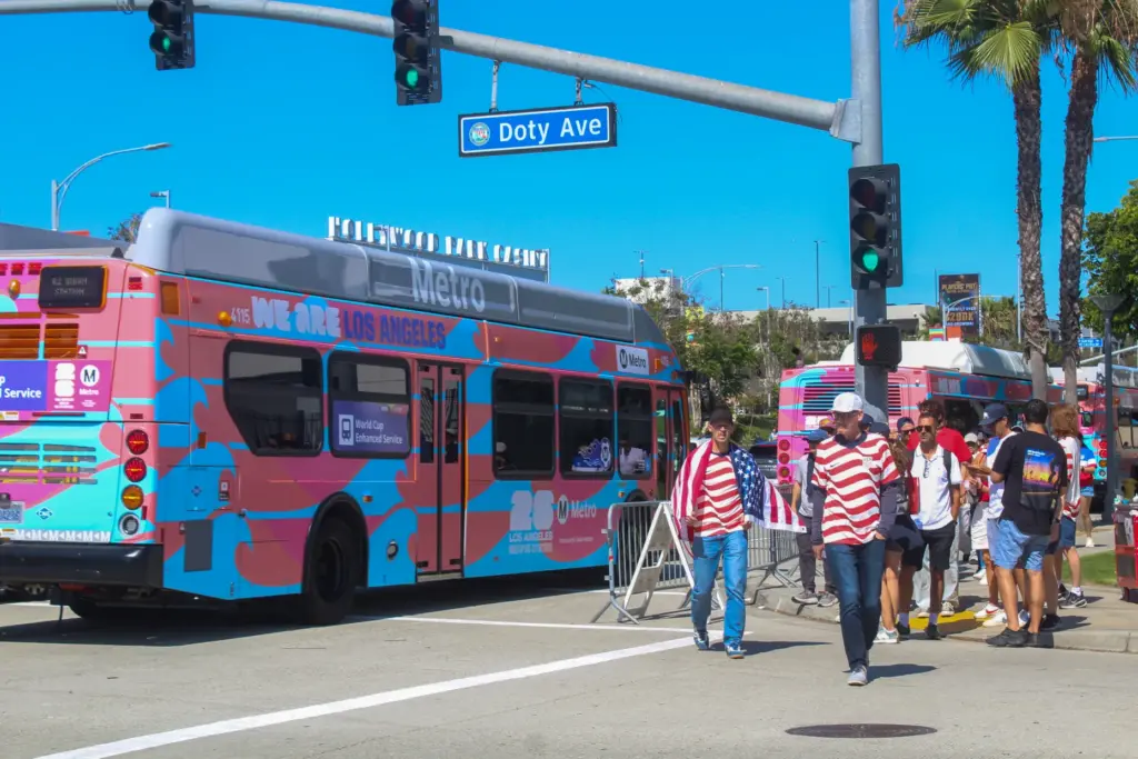 Team USA fans walking past a LA Metro bus carrying...