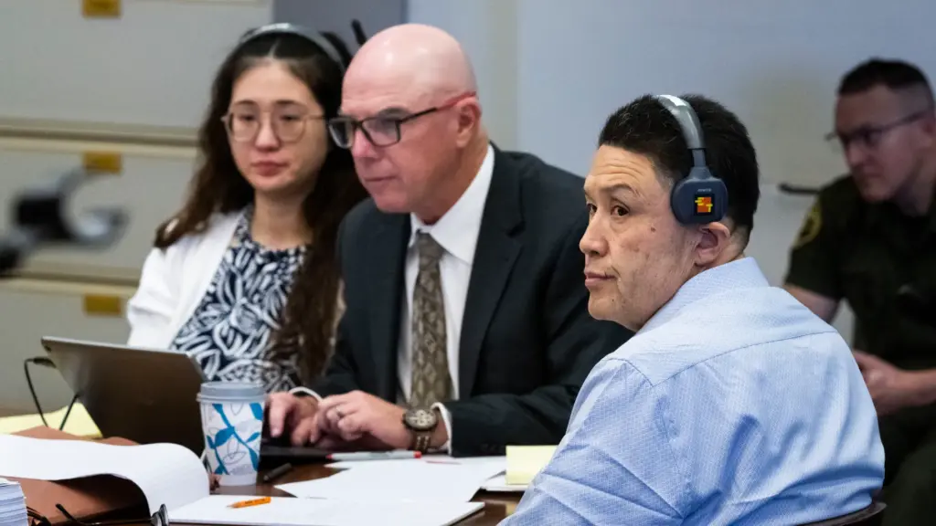 Kwong Chun Sit, right, listens to opening statements in court...