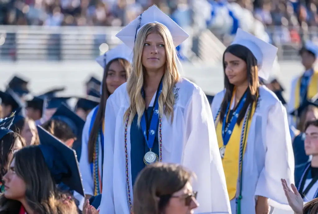 International Baccalaureate Diploma candidates stand to be recognized during the...