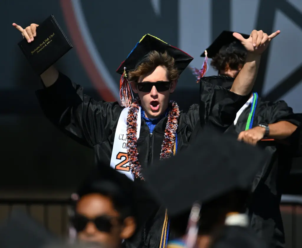 Isaiah McRae shows his excitement after receiving his diploma during...