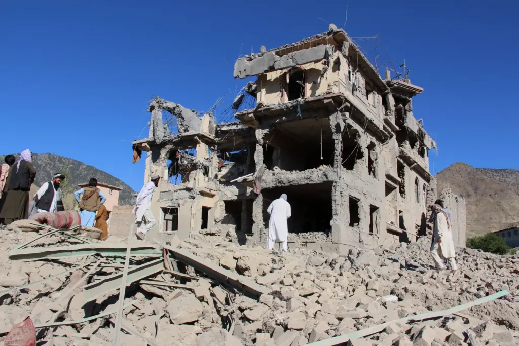 Residents walk through the rubble in Mandokhail, Afghanistan.