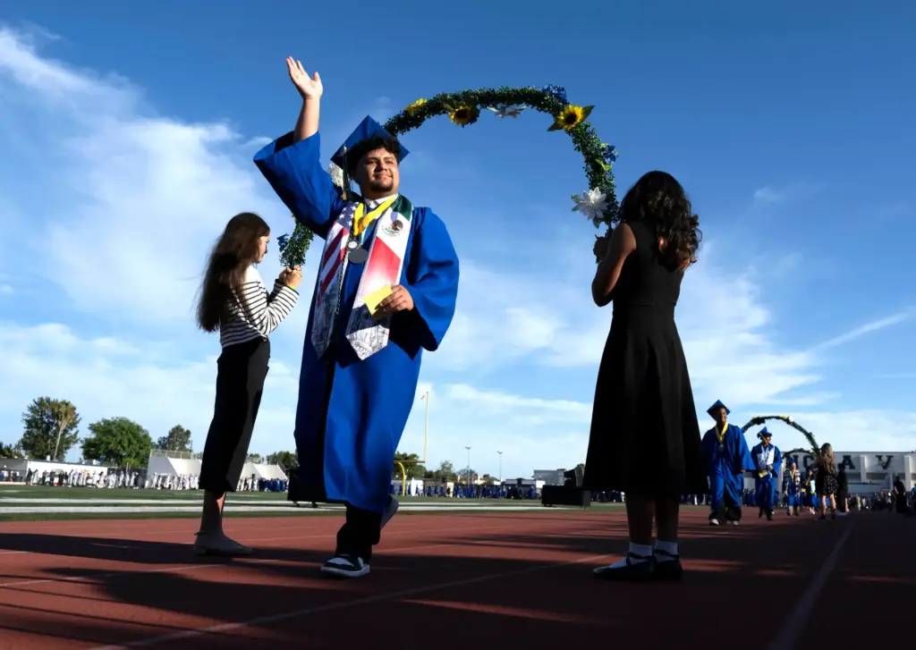 As he enters Bradford Stadium, a graduate waves to his...