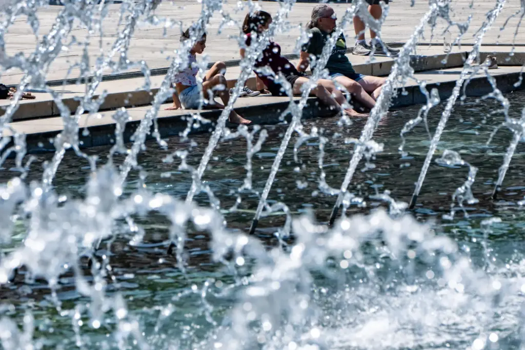 People cool their feet in the fountain at the WWII...