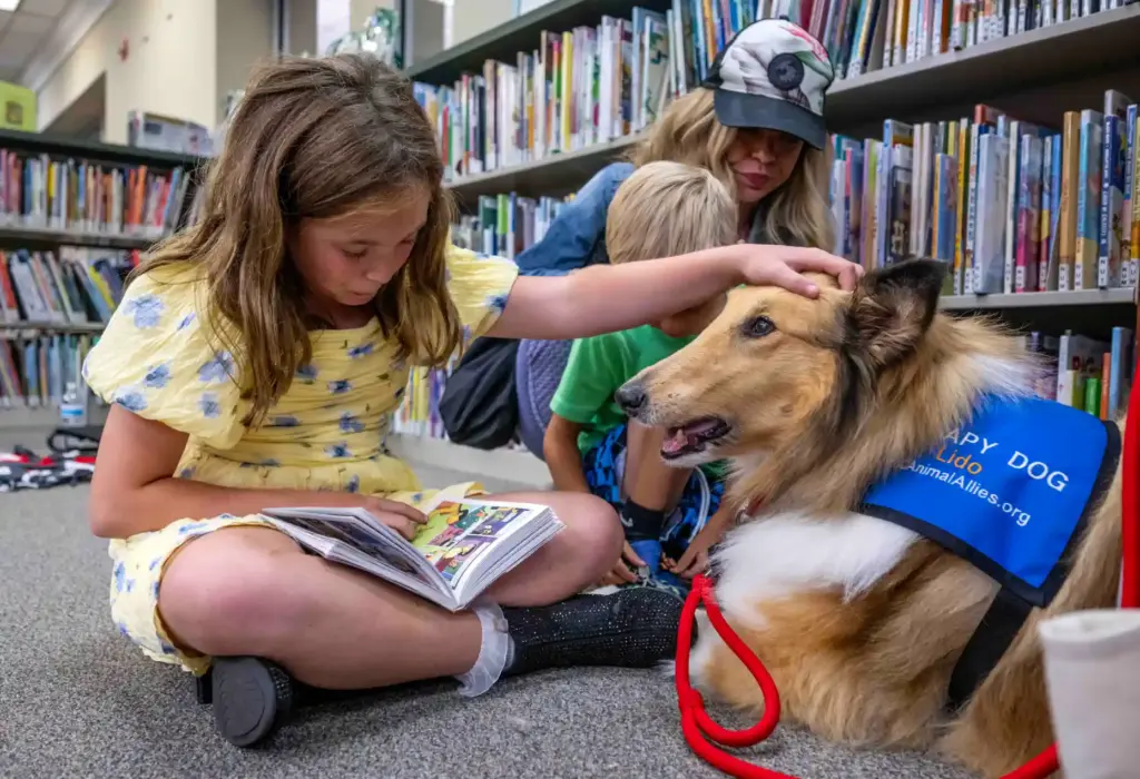 Chloe, 10, of Ladera Ranch, a third grader, pets Lido,...