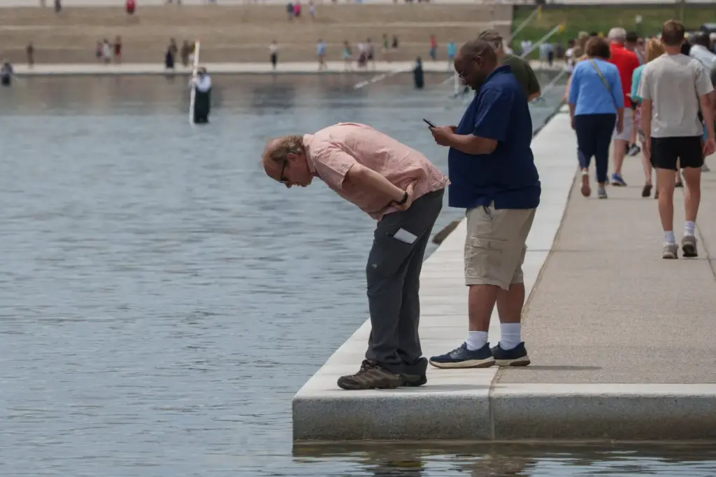 Visitors look into the Lincoln Memorial Reflecting Pool as National...
