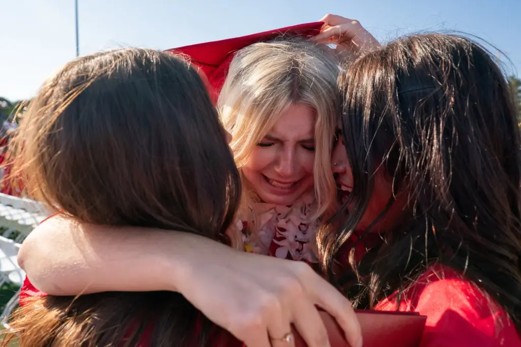 Alexa Lyncheski, center, breaks down while hugging Sara Ishani, right,...