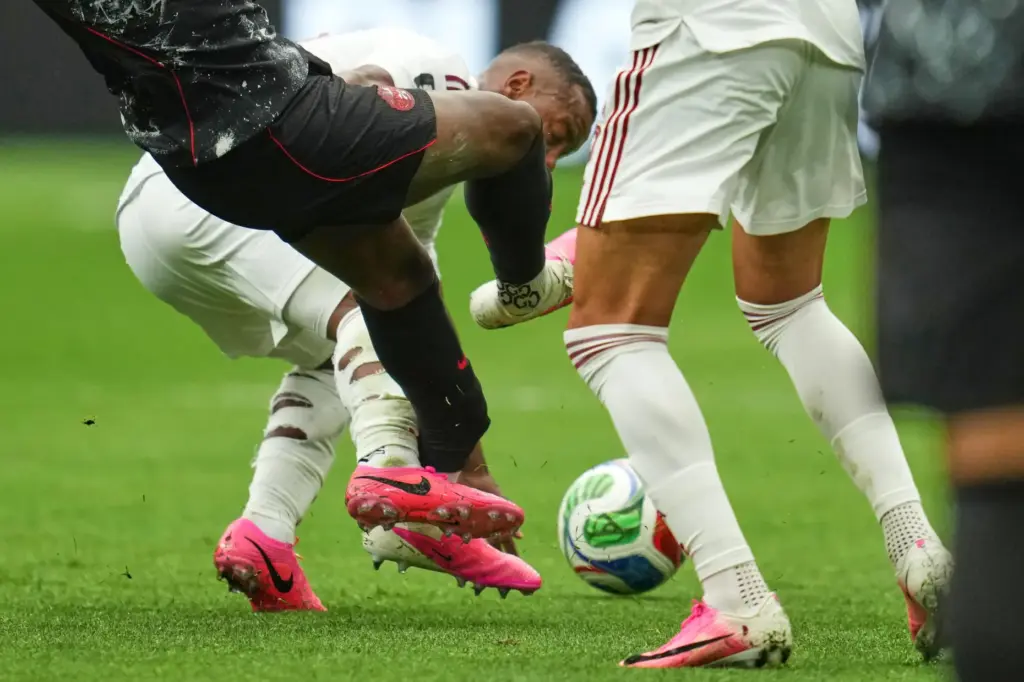 Canada’s Ismael Kone, left, falls while being fouled against by...
