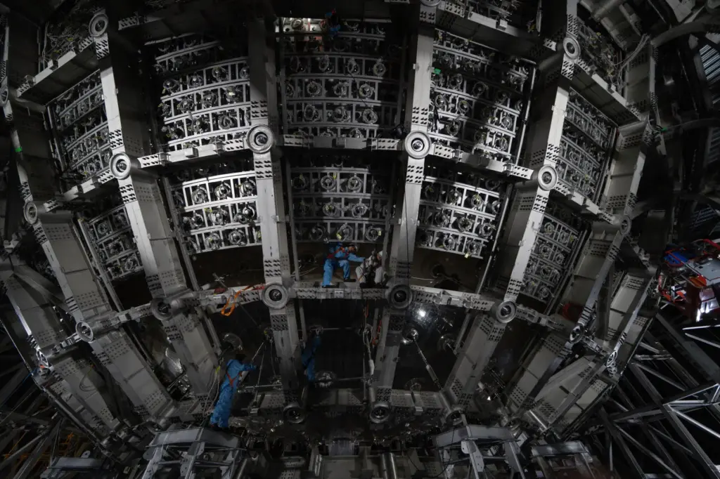FILE – Workers labor on the underside of the cosmic...