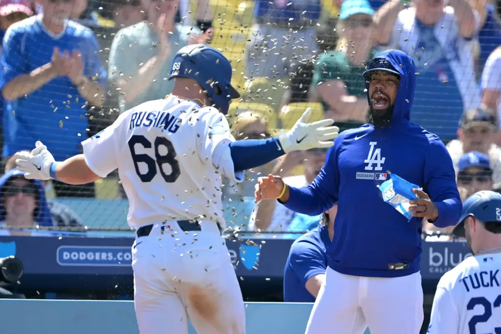 Dodgers’ Dalton Rushing, left, gets a sunflower seed shower from...