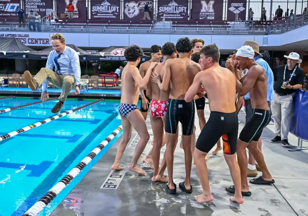 Aquinas coach Loren McCoy leads the way into the pool...
