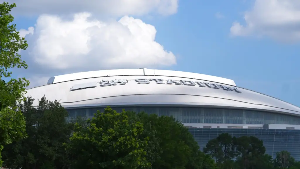 Workers cover signage on the exterior of AT&T Stadium, which...