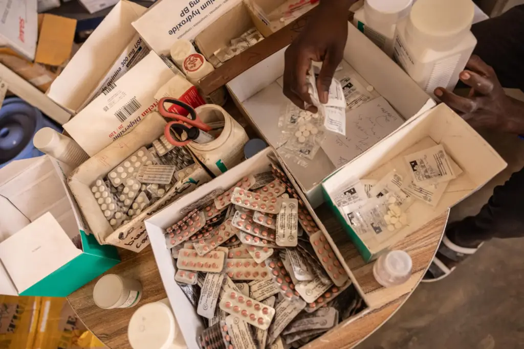 A pharmacist hands pregnant women painkillers from boxes at the...