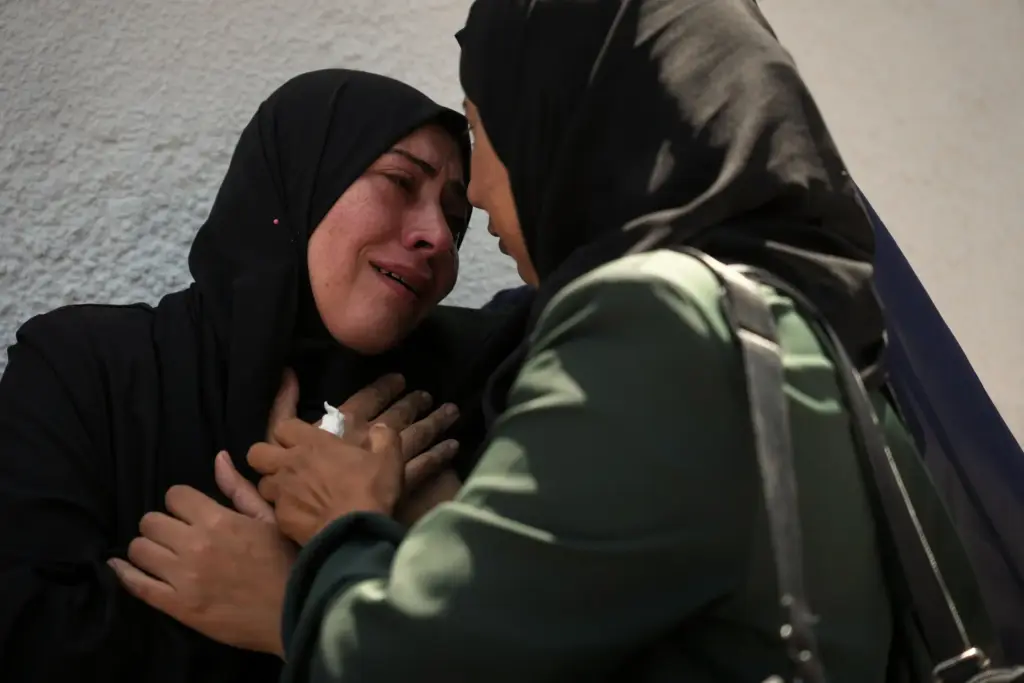 Palestinians attend the funeral of their relatives who were killed...