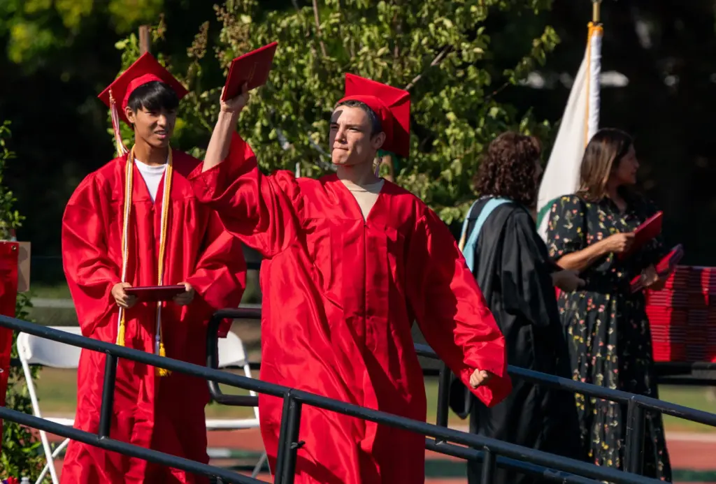 Matthew Waggoner raises his diploma during the Woodbridge High School...