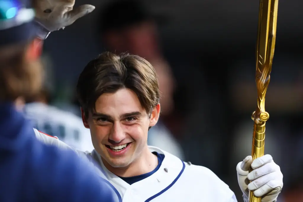 The Seattle Mariners’ Cole Young smiles in the dugout after...
