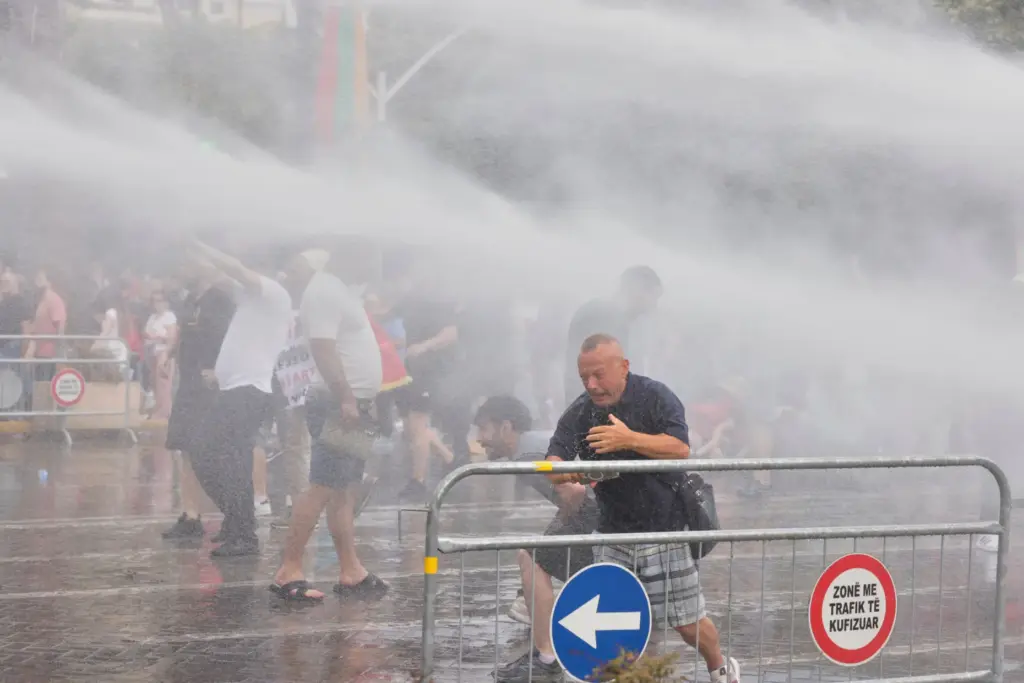 Police use a water cannon to disperse protesters during a...
