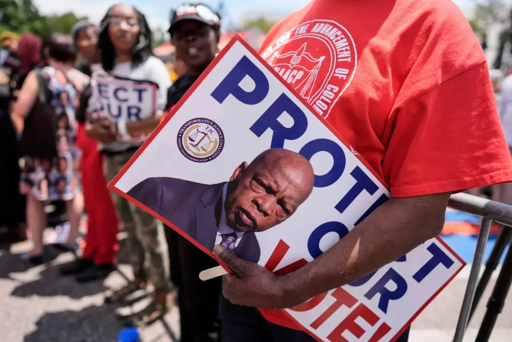 A protestor holds a sign of the late Georgia Congressman...