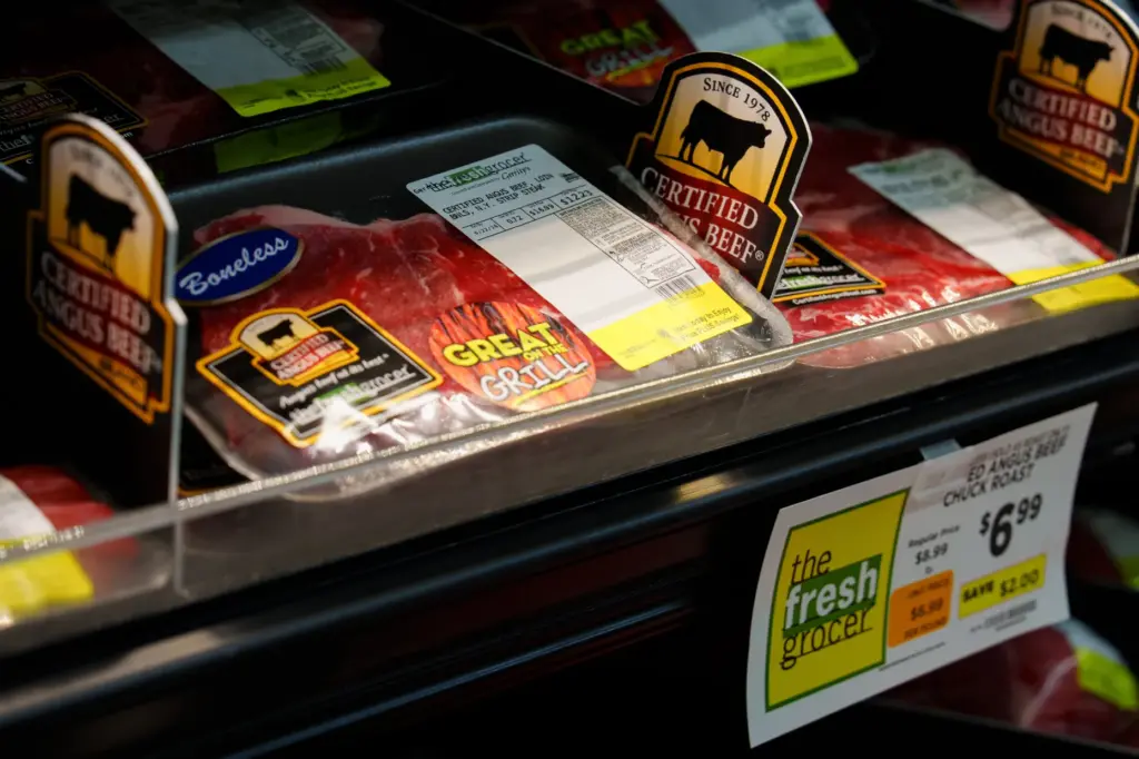 Packages of N.Y. strip steaks sit on a shelf in the meat section.