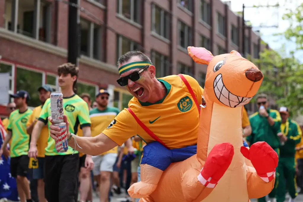 An Australian fan celebrates as fans march to match before...