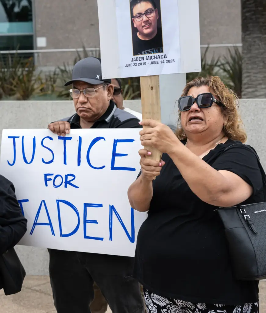 Distraught family members hold signs during a press conference announcing a claim against the city of Santa Ana. (Photo by Mindy Schauer, Orange County Register/SCNG)