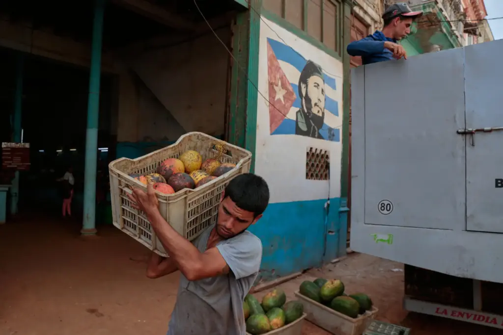 A worker unloads boxes of fruit at a state-run market...