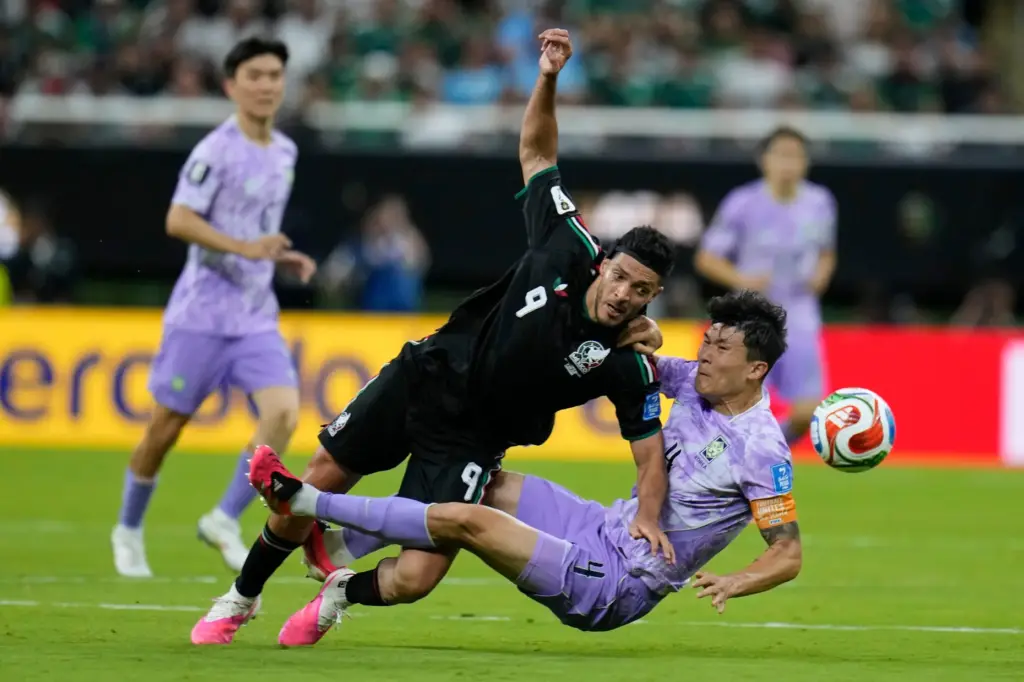 Mexico’s Raul Jimenez (9), center, vies for the ball with...