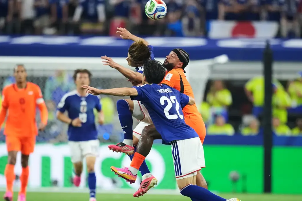 Japan’s Takehiro Tomiyasu (22), Kaishu Sano, left, and Netherlands’ Memphis...
