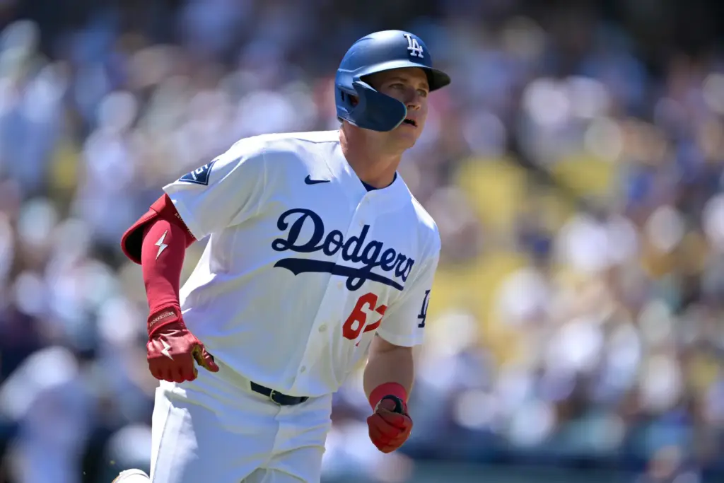 Dodgers’ Ryan Ward rounds the bases after hitting his first...