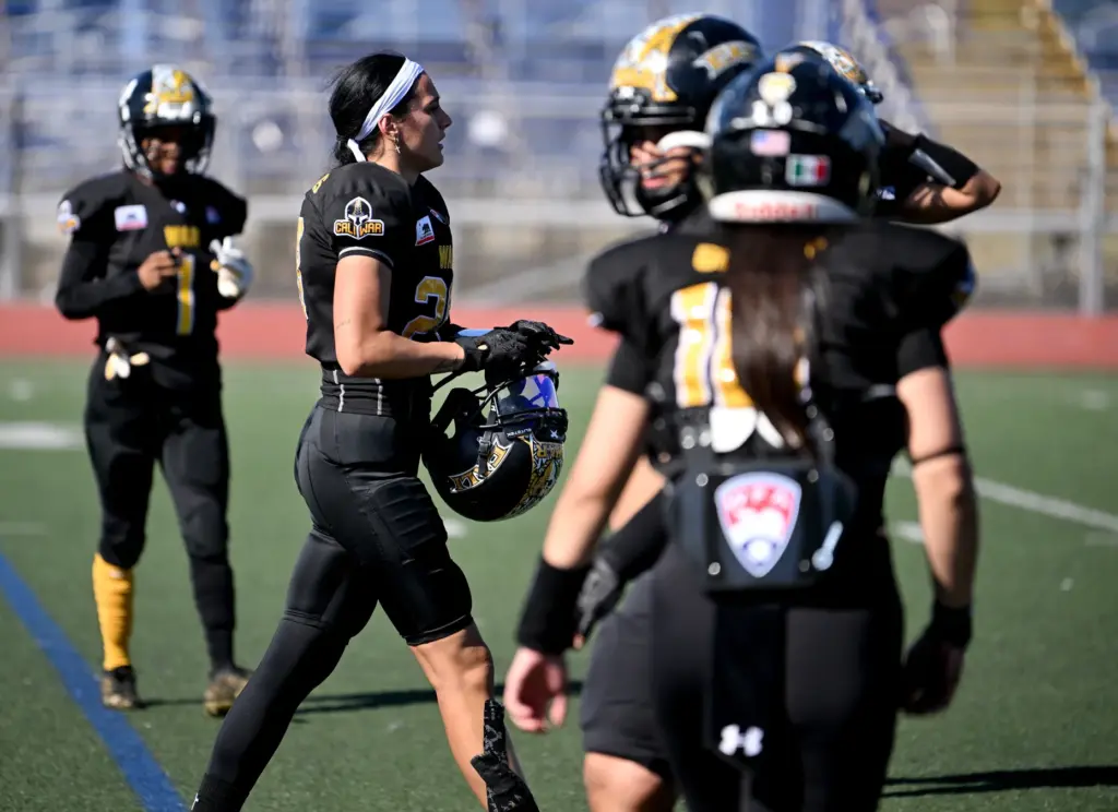 Cali War defensive back Alyssa Williams, second from left, gets...
