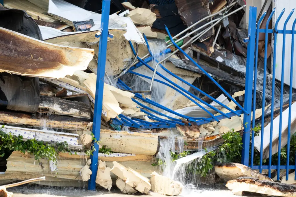 Thousands of gallons of water flows over debris at the...