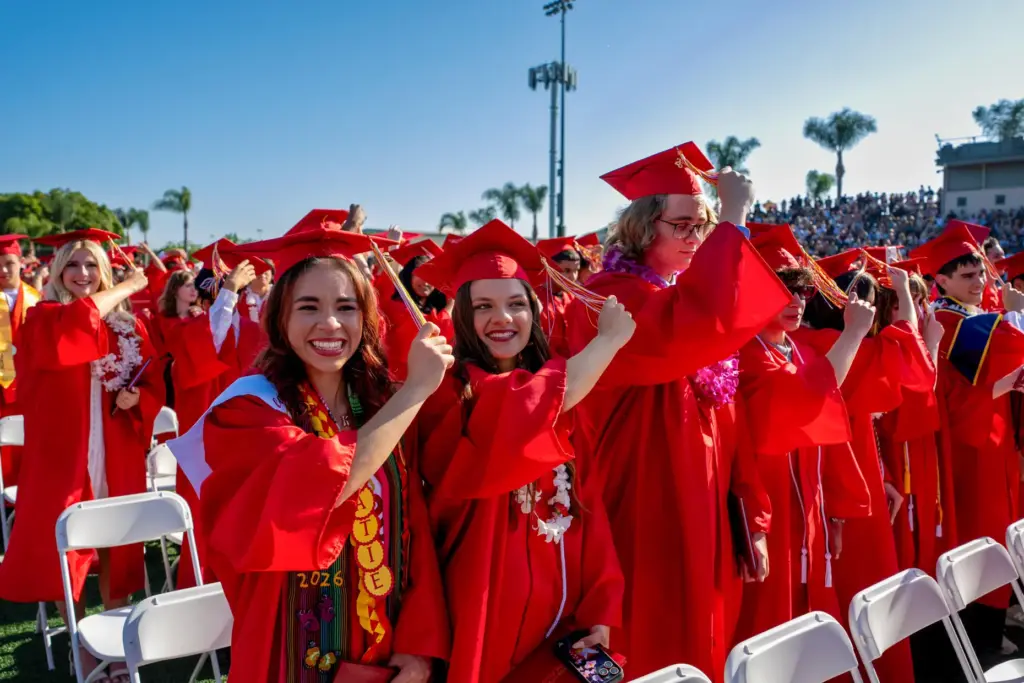 Katie Melendez, left, and Olivia Lopez move their tassels during...