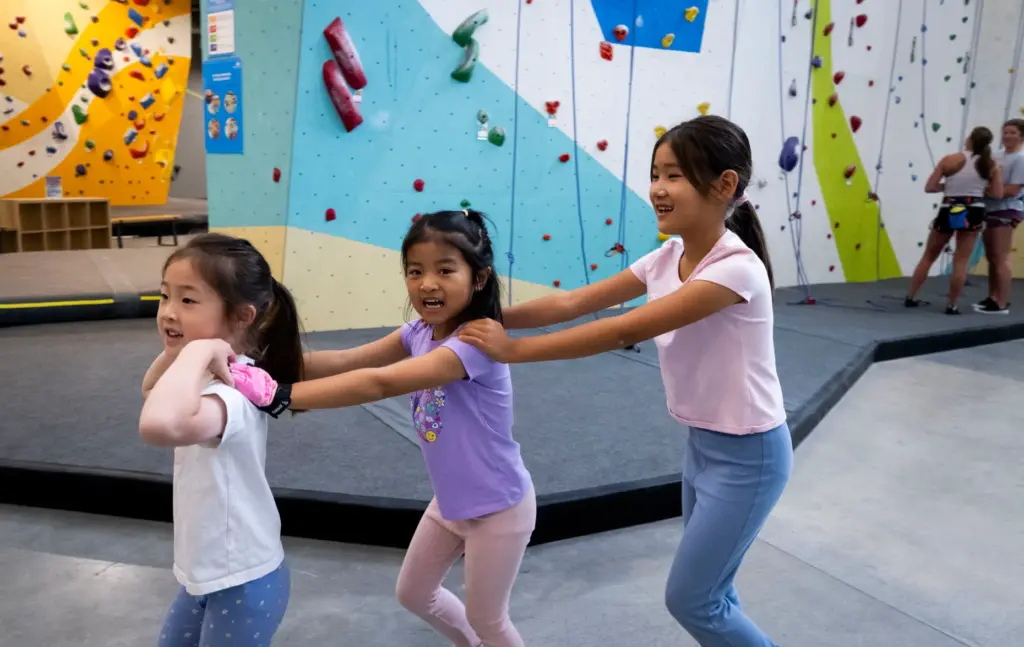 Three campers do a conga line on their way to...