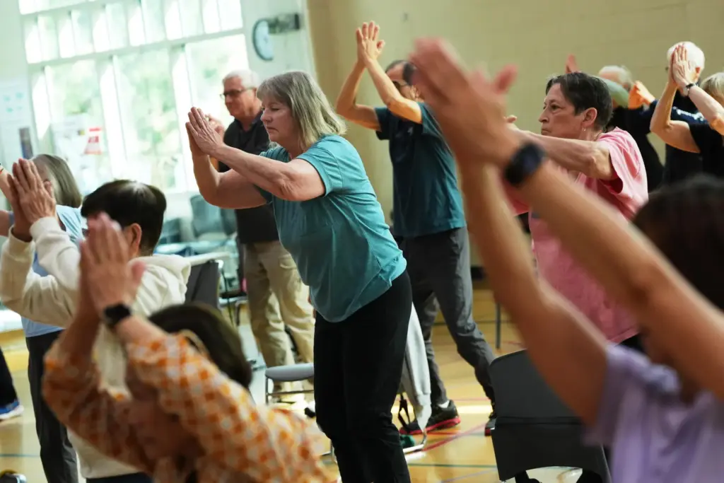Participants do arm exercises during an exercise class for older adults.