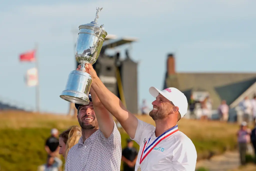 Wyndham Clark celebrates with his caddie David Pelekoudas after winning...