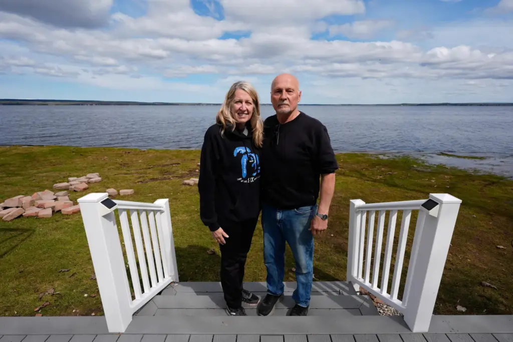 Tom and Diane Peterman pose outside their home at Black Lake.