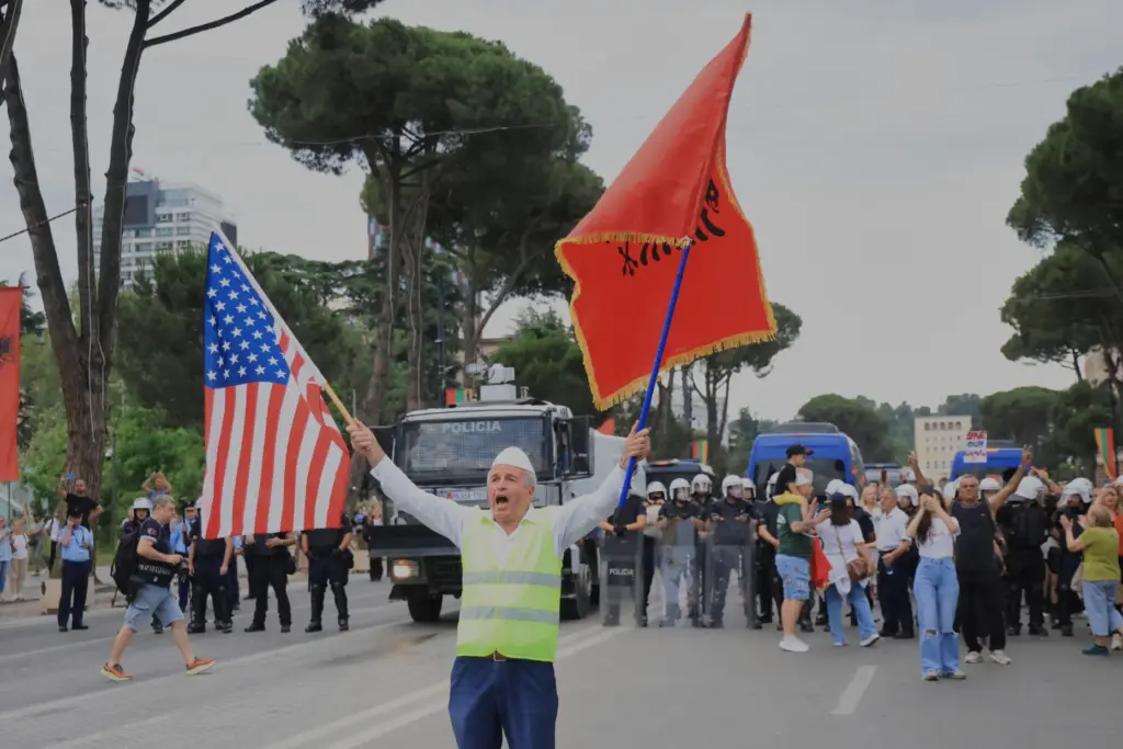 A protesters holds a US and an Albanian flag during...