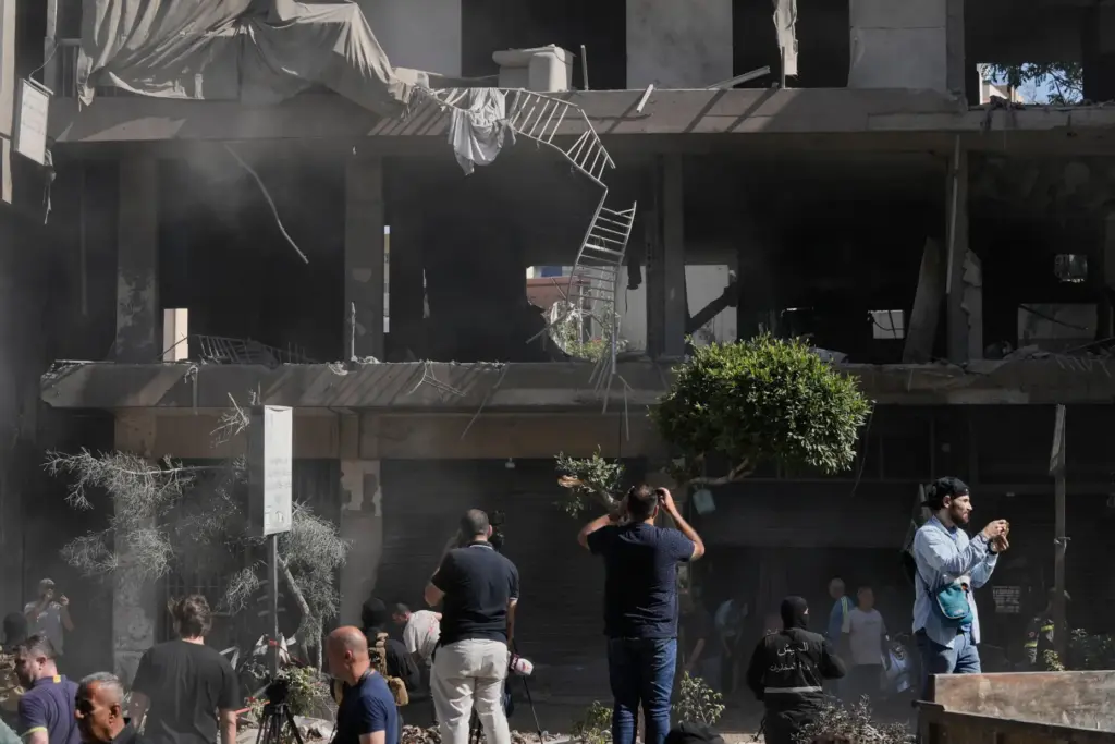 People gather at the site of an Israeli airstrike that...