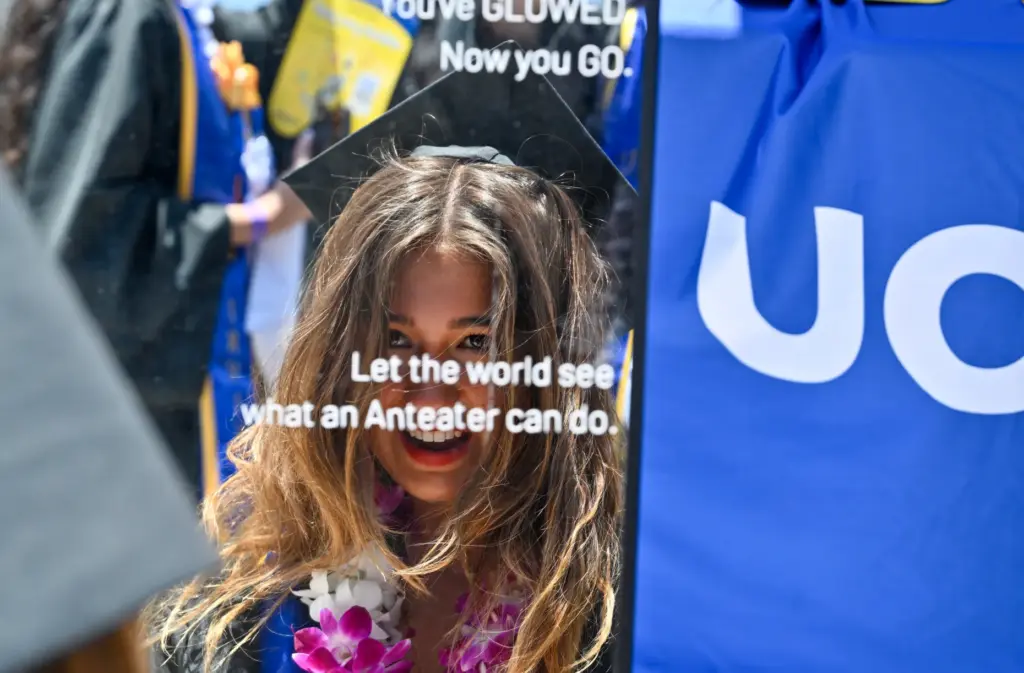 Graduate Grace Kalmbach uses a mirror to check herself before...