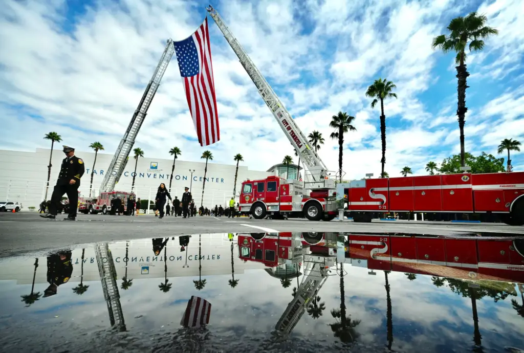 Two ladder trucks display the American Flag on Monday, Aug....